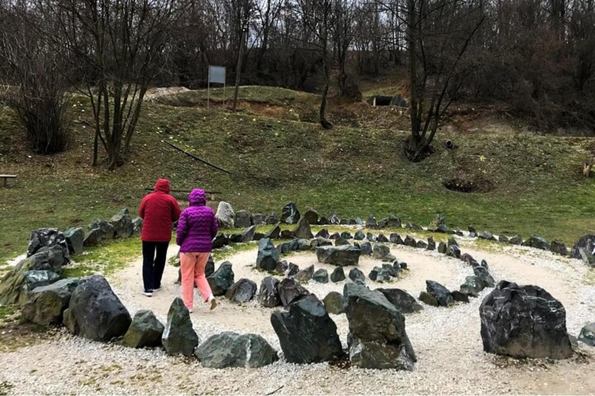 um homem e uma mulher caminhando por um labirinto de pedras