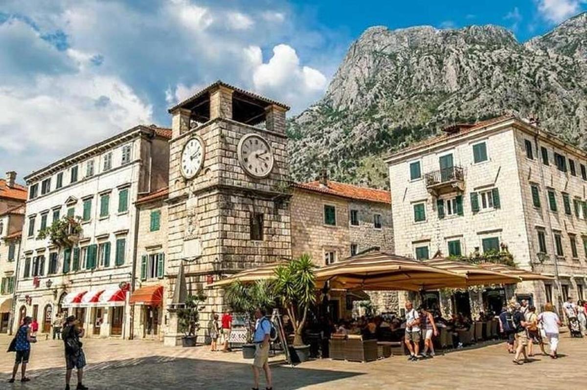 un edifici amb una torre de rellotge i una muntanya al fons