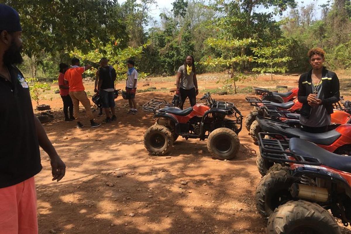 a group of people standing around a group of atvs