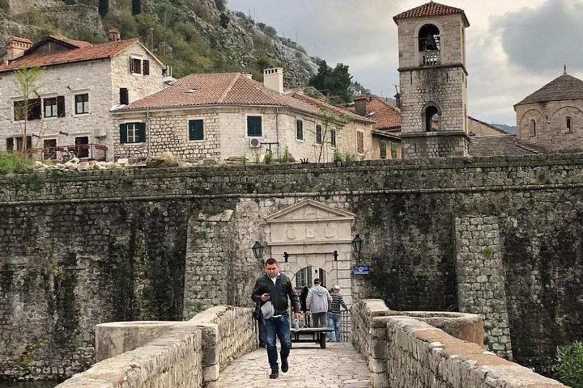 un home caminant per un pont de pedra