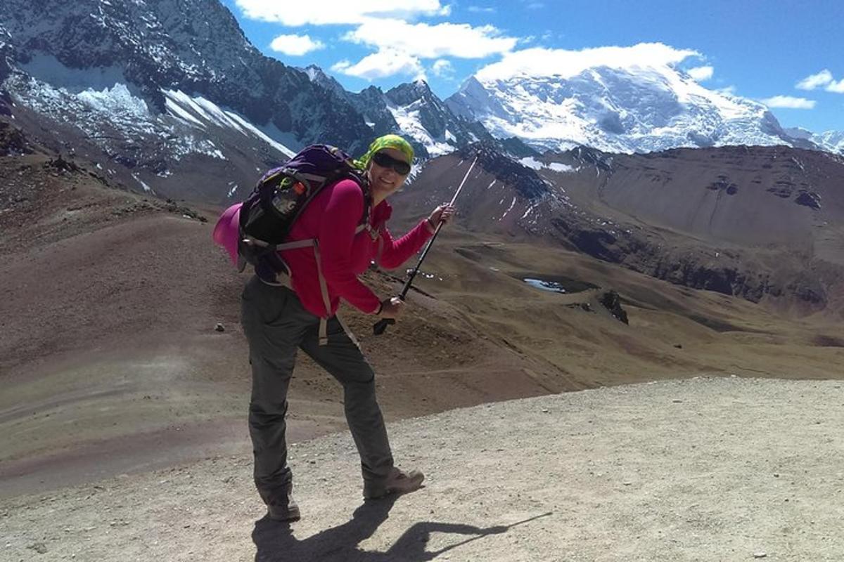 eine Frau mit einem Rucksack steht auf einem Berggipfel