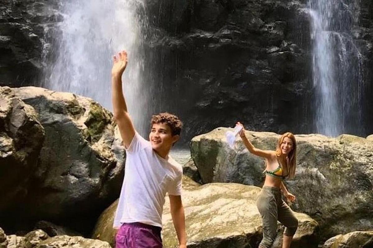 due persone in piedi sulle rocce di fronte a una cascata
