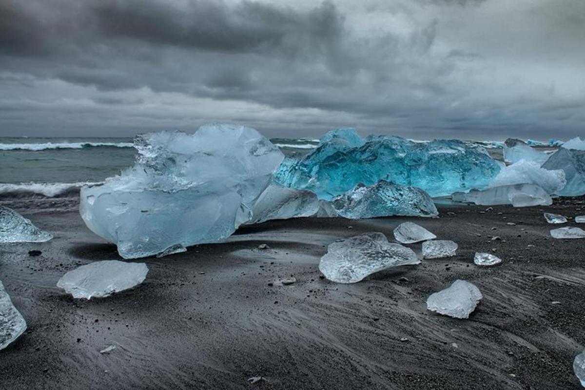 um grupo de icebergs em uma praia perto do oceano