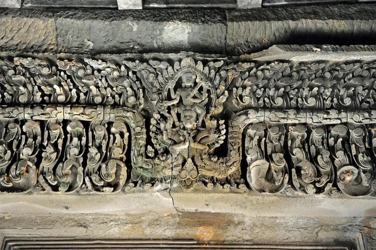 um muro de pedra com uma escultura na lateral de um edifício