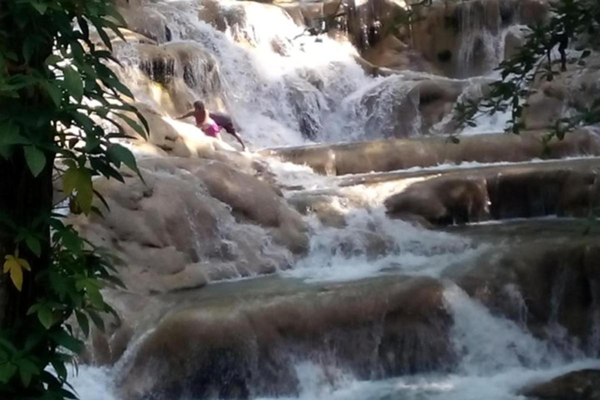 una persona è seduta sulle rocce in una cascata