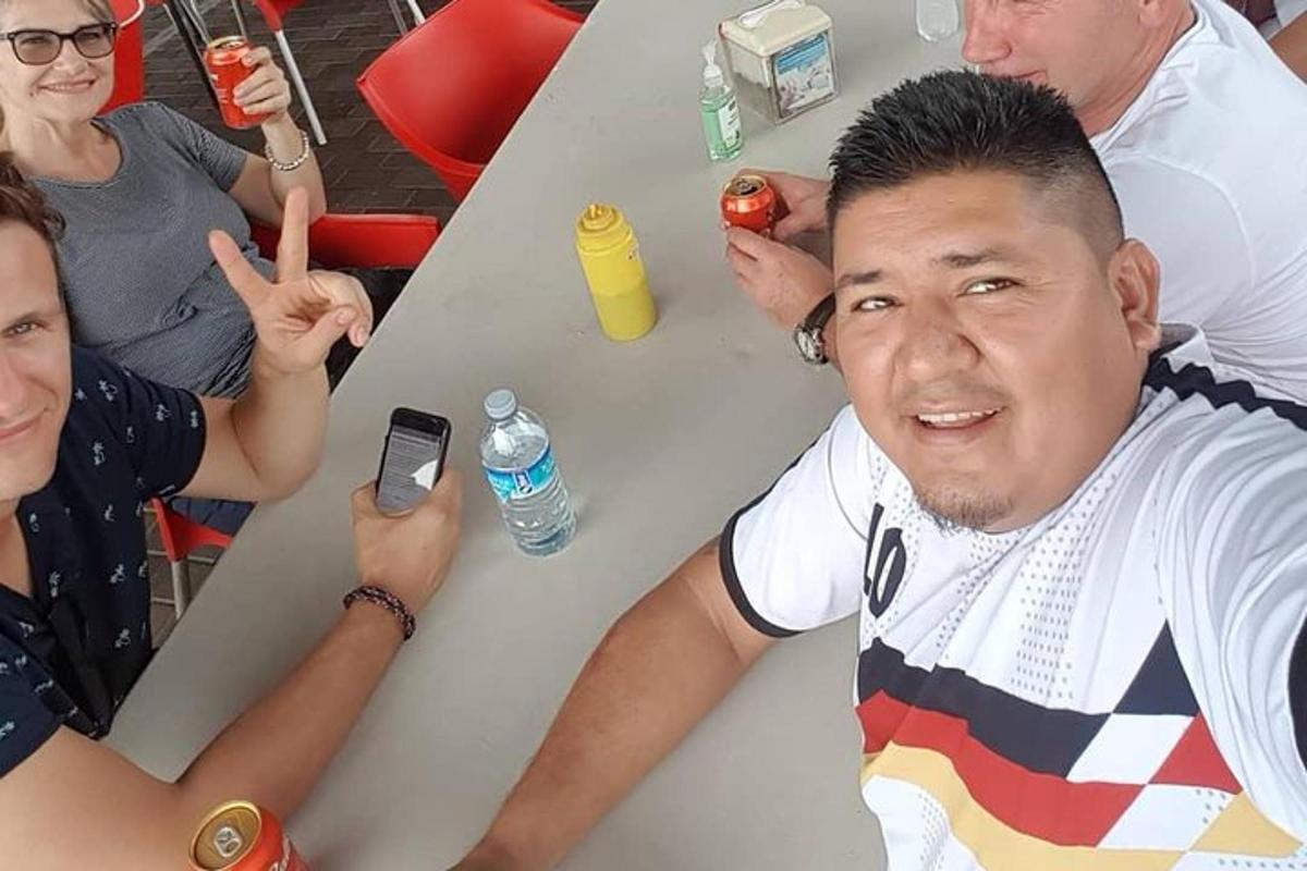 muž sedící u stolu s lidmi sedícími kolem