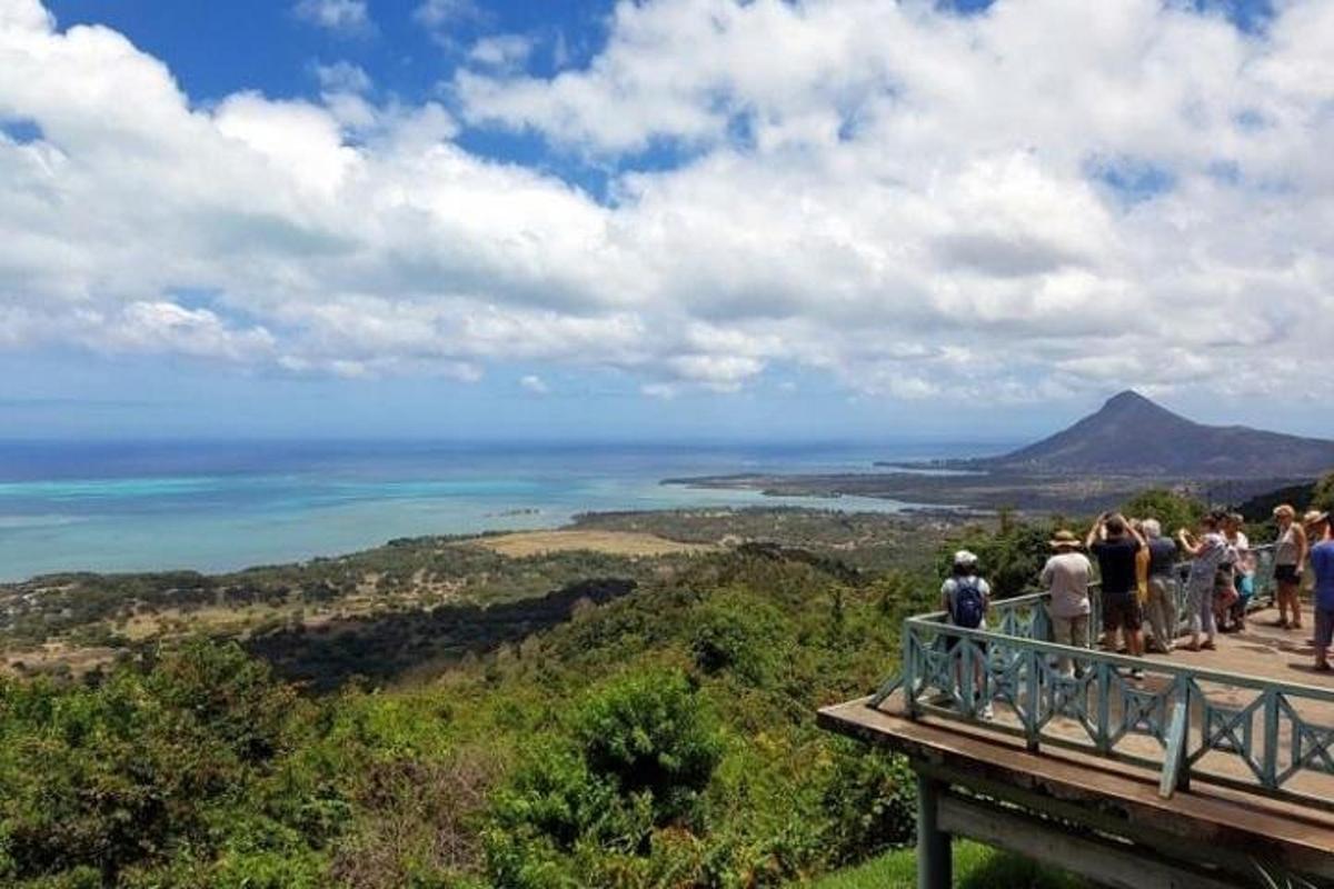 a group of people standing on the edge of a viewing deck overlooking the ocean