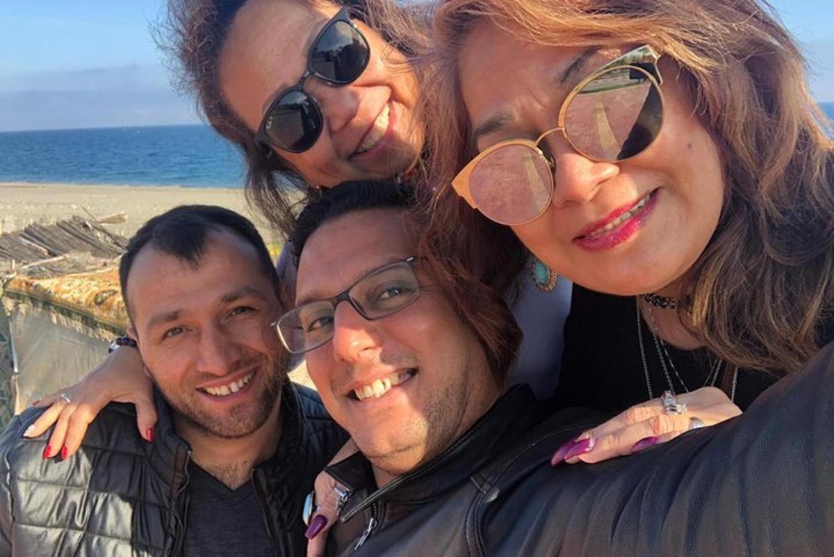 група људи позира за фотографију на плажи