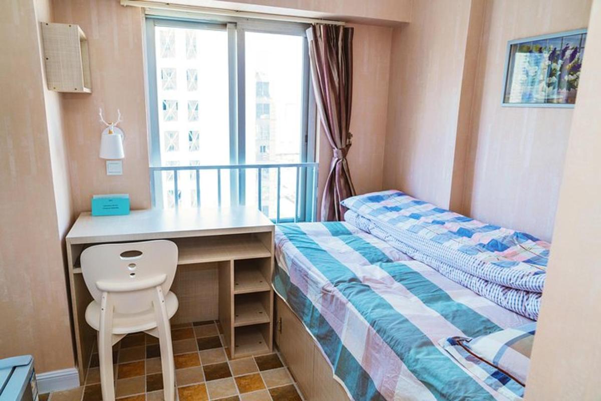 một phòng ngủ nhỏ có giường và bàn làm việc