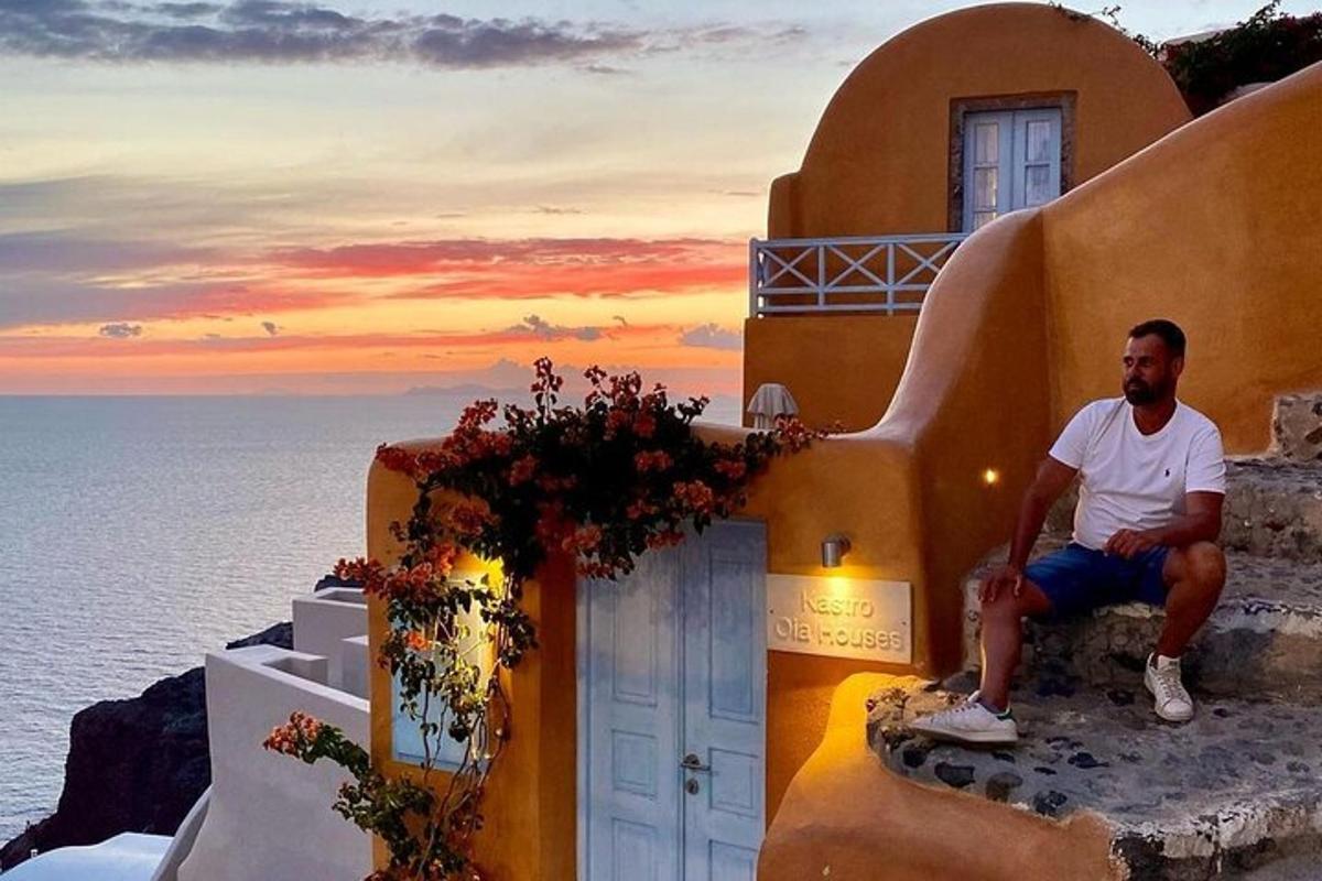 un bărbat așezat pe marginea unei clădiri cu vedere la ocean