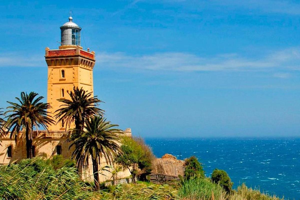 un faro situato in cima a una collina vicino all'oceano