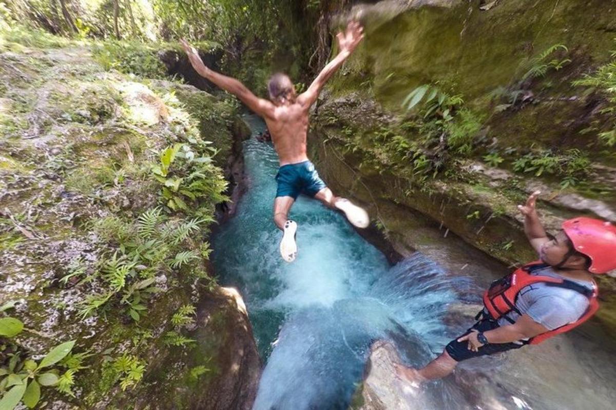 dois homens pulando em um riacho de um rio