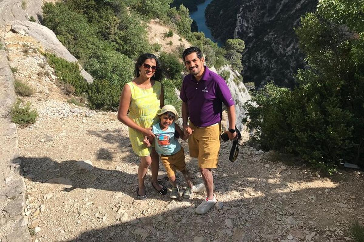 um homem, uma mulher e uma criança em pé em uma montanha