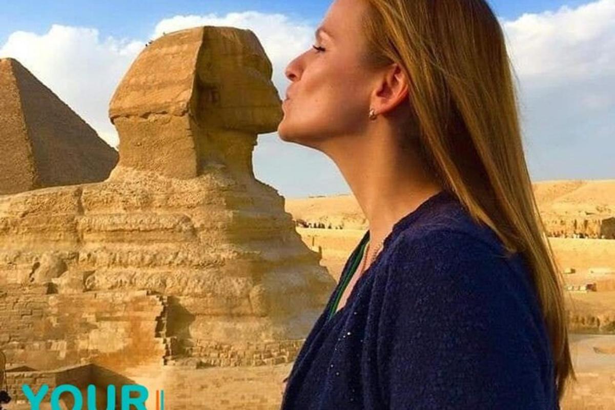 a woman standing in front of the pyramids
