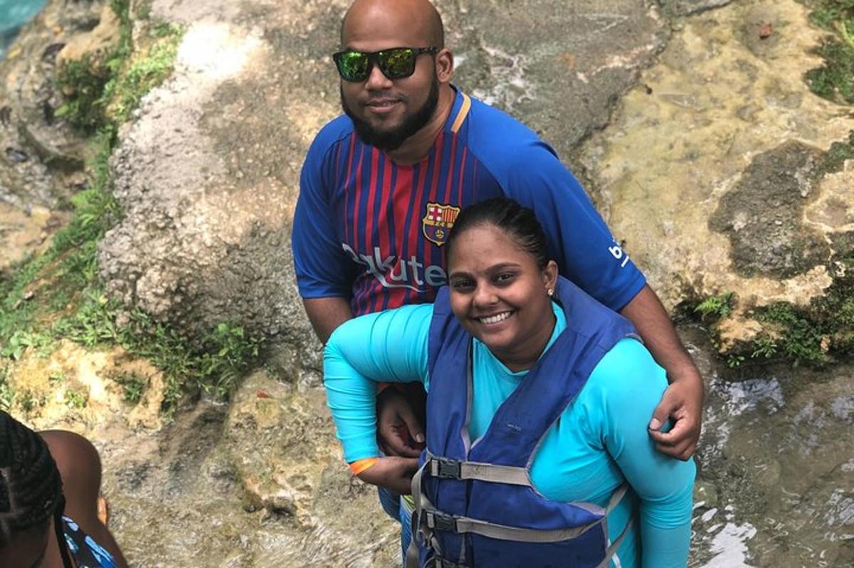 um homem e uma mulher em pé sobre uma rocha
