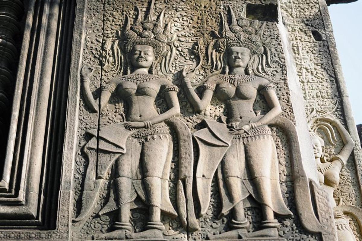 uma escultura em pedra de duas mulheres na lateral de um prédio