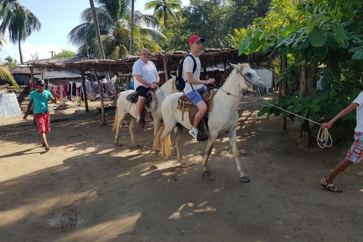 a group of men riding horses on a beach