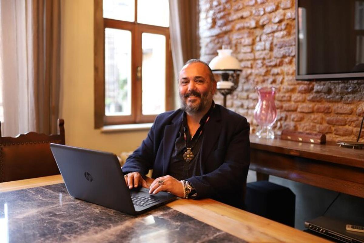 a man sitting at a table with a laptop computer
