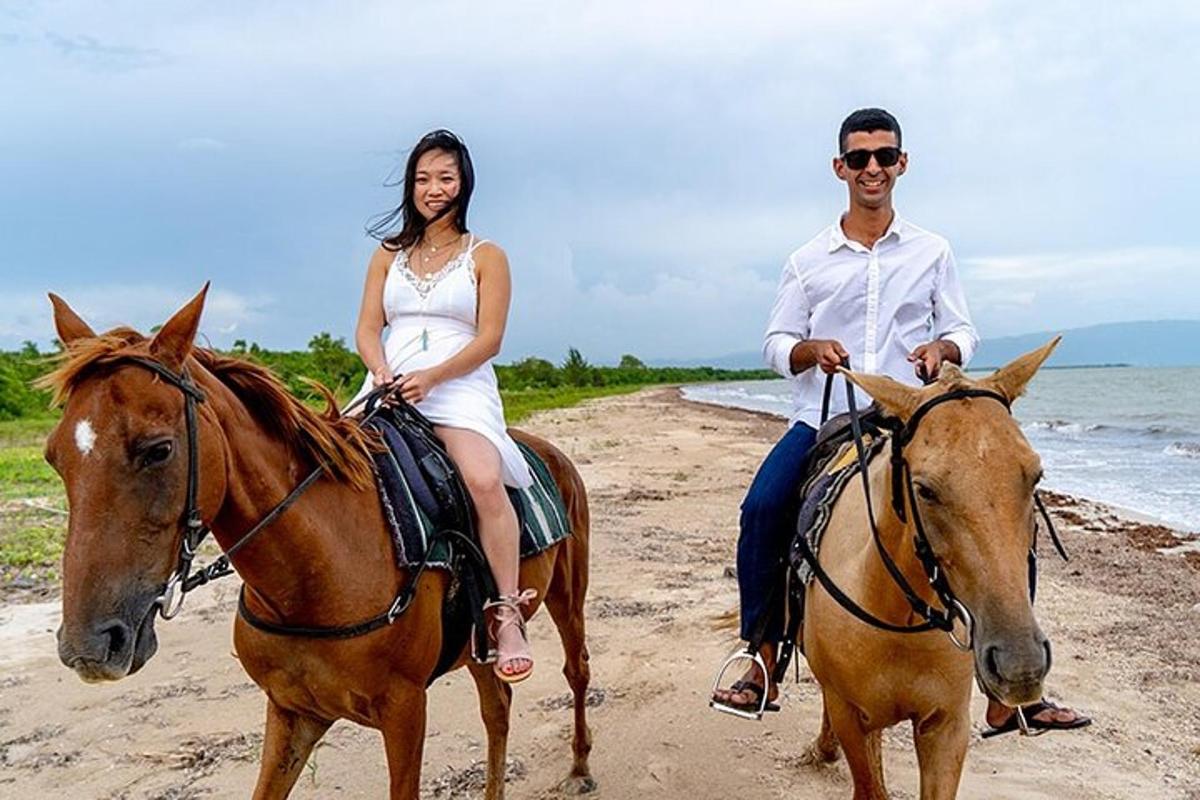 um homem e uma mulher cavalgando na praia