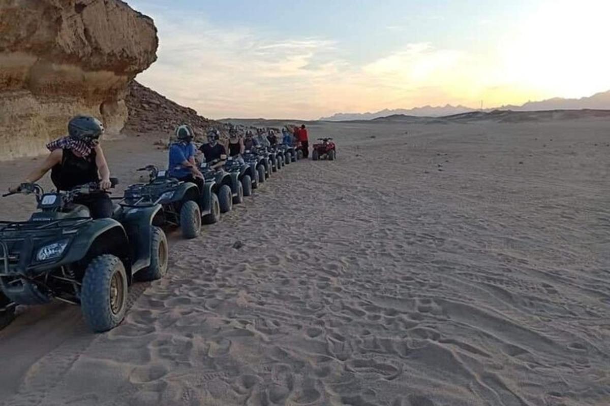 un grup de persones conduint quads al desert