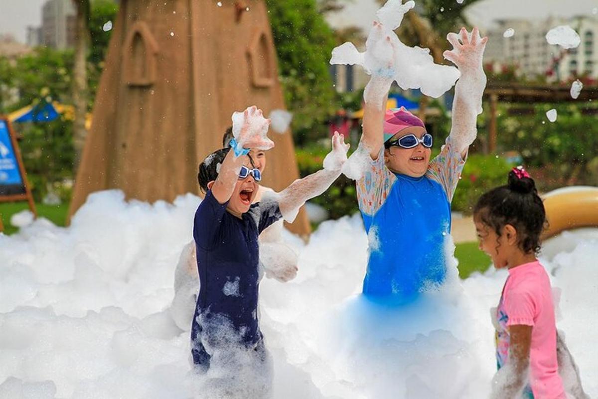 three children playing in the snow at a playground