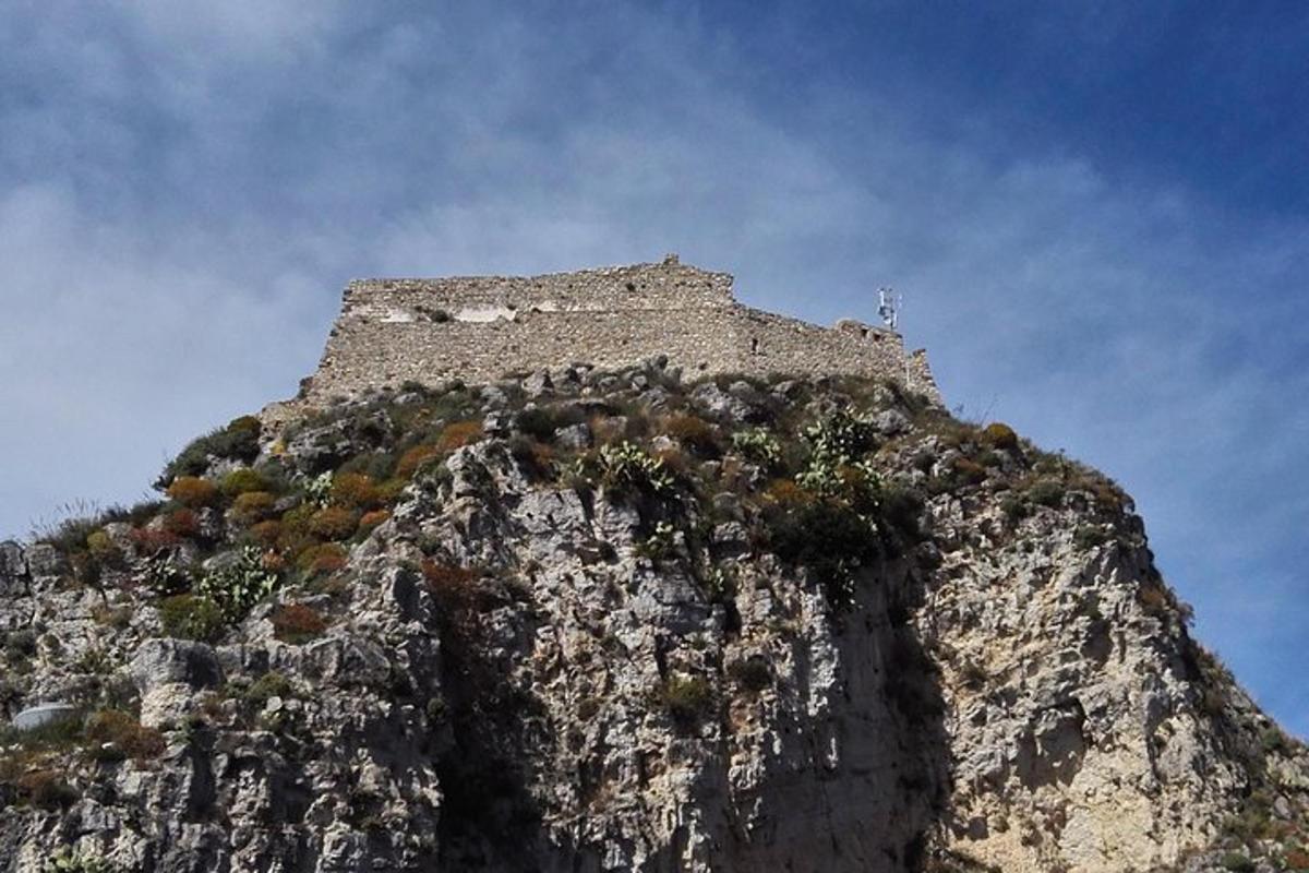 a rocky mountain with a building on top of it