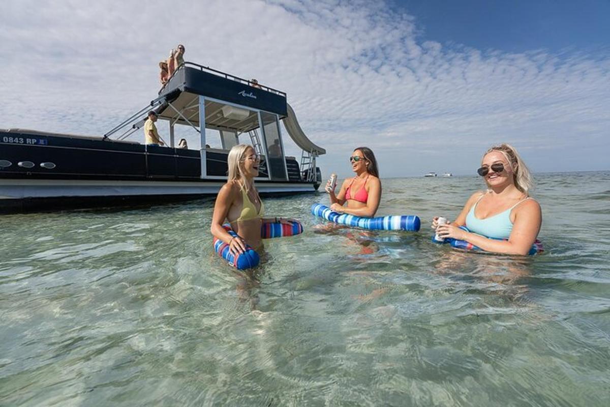 drie vrouwen zitten in het water voor een boot