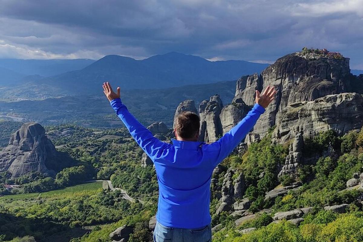 seorang lelaki berdiri di atas gunung dengan tangan dihulurkan