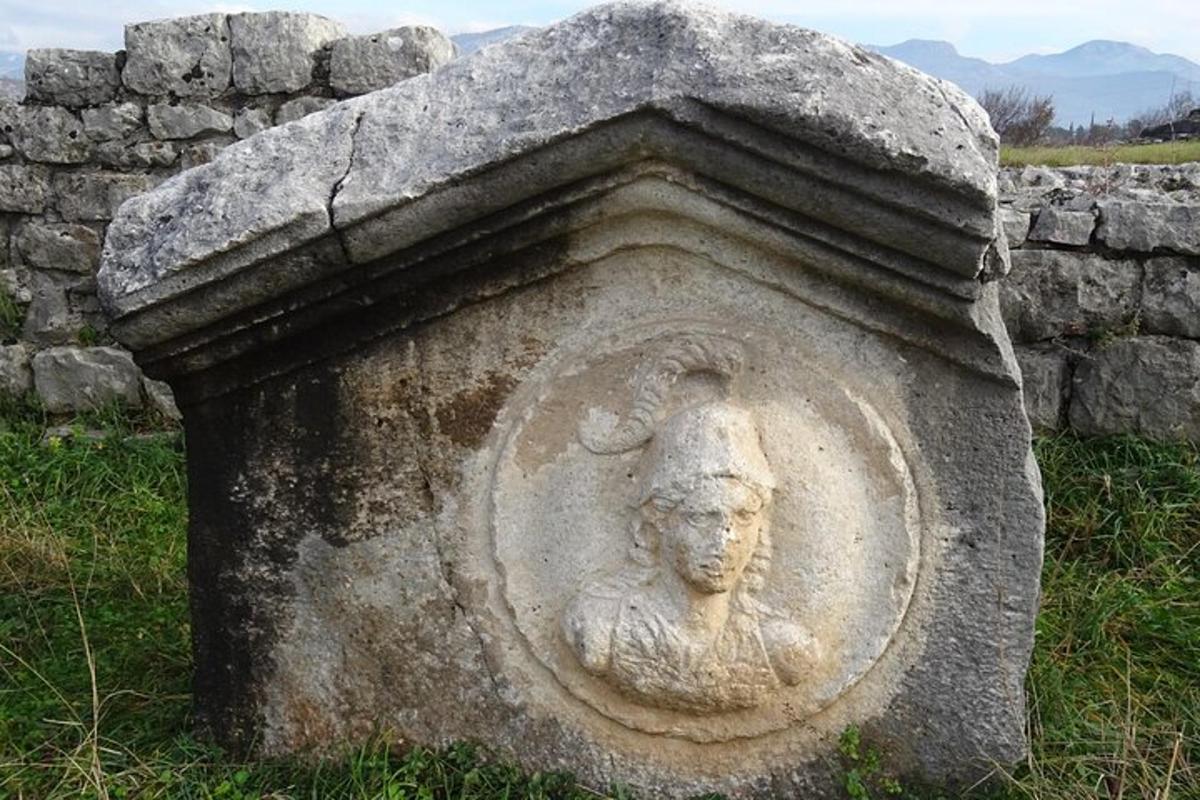 o statuie de piatră a unei oi pe un zid de piatră