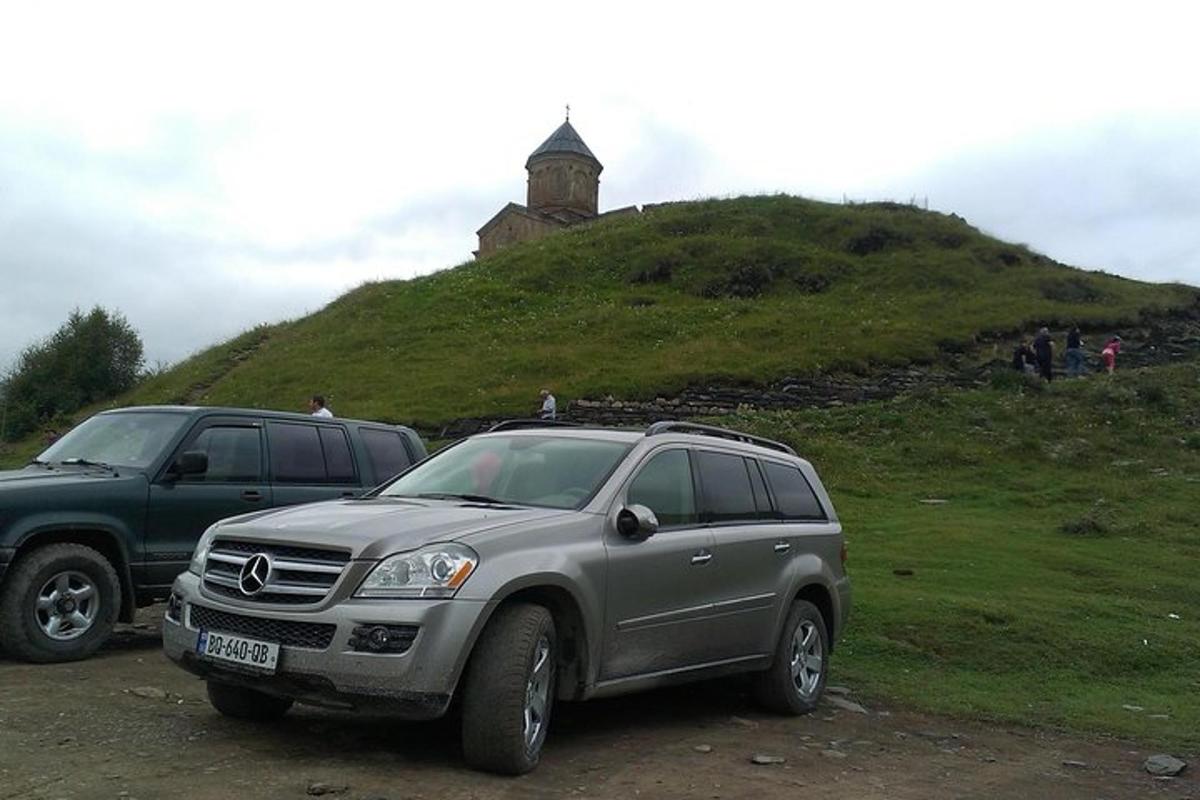 due SUV parcheggiati su una collina erbosa con un faro