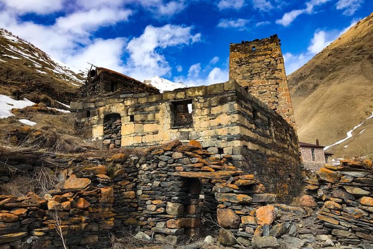 un vecchio edificio in pietra sul fianco di una montagna