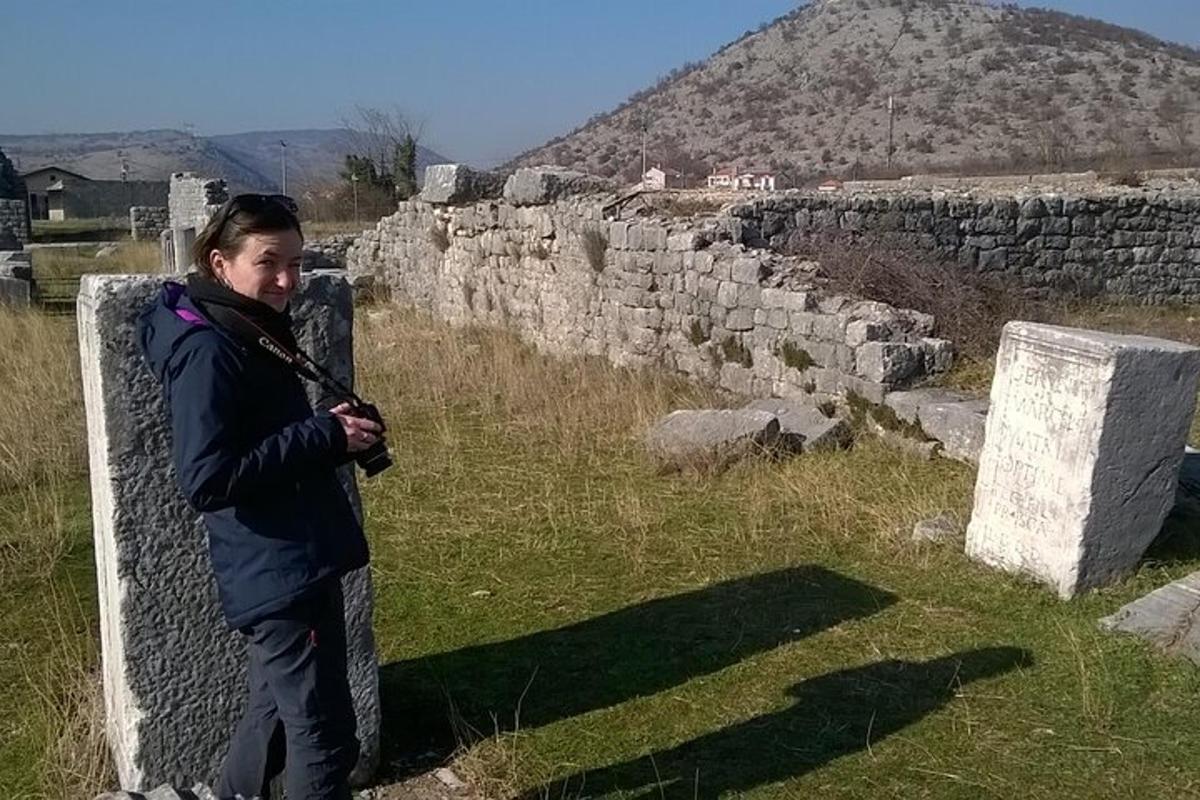 un ragazzo in piedi accanto a un muro di pietra