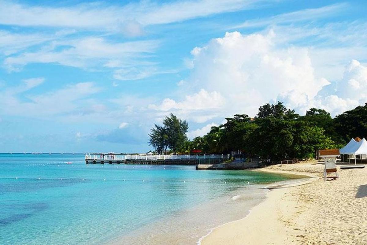 pantai berpasir dengan dermaga di dalam air