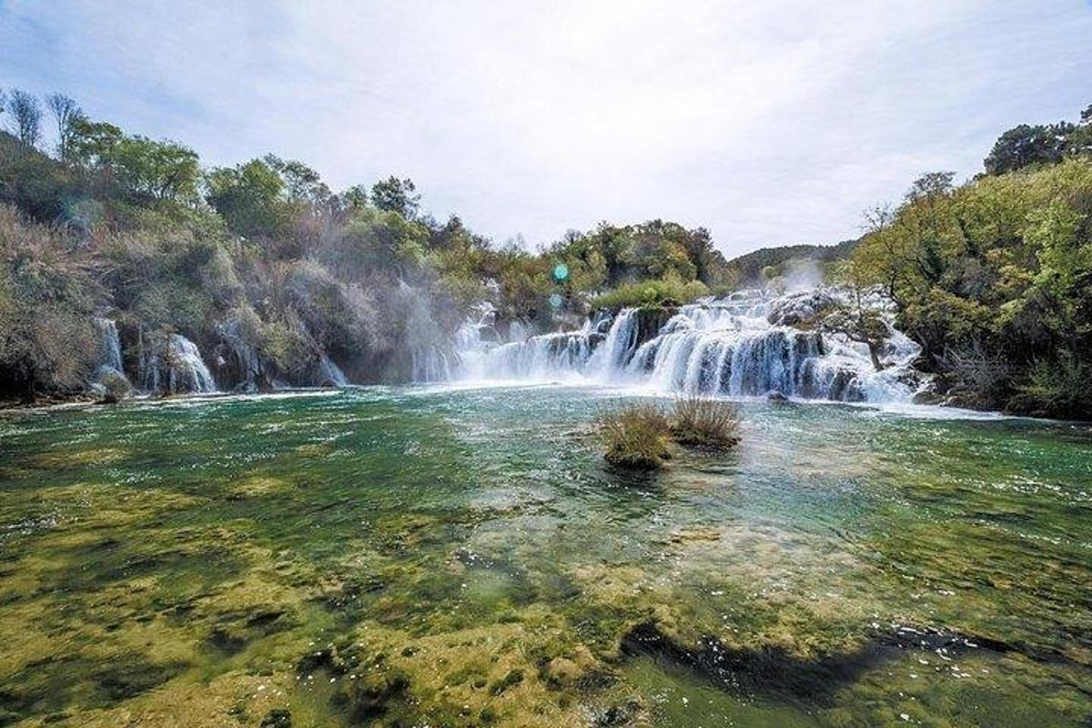 a waterfall in front of a body of water