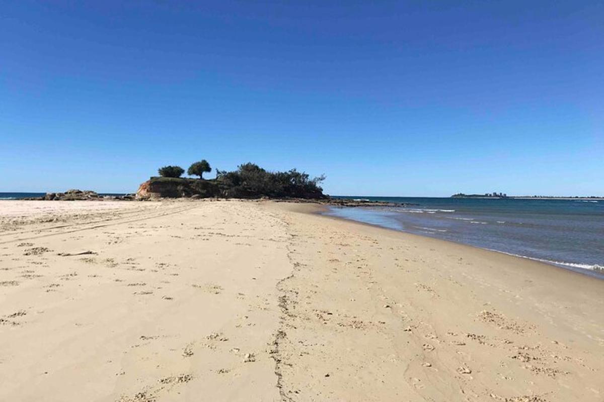 a beach with footprints in the sand and the ocean