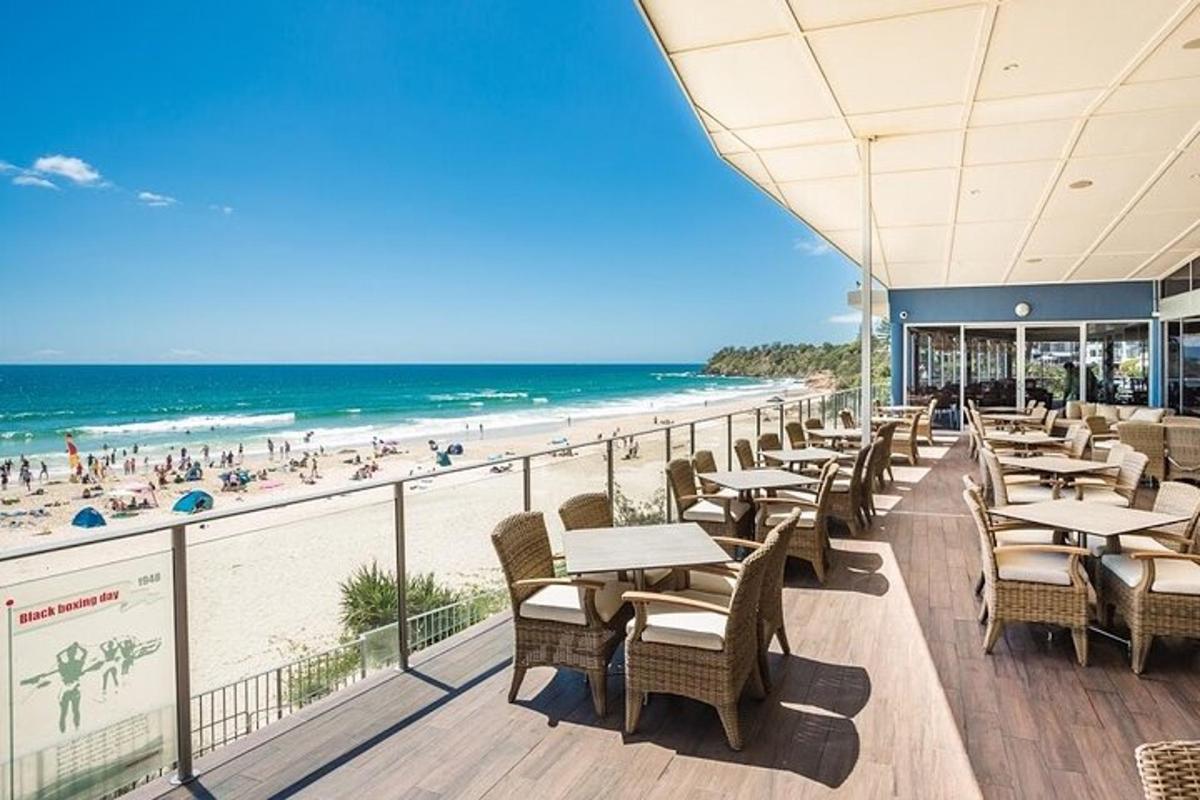 a restaurant with tables and chairs on the beach
