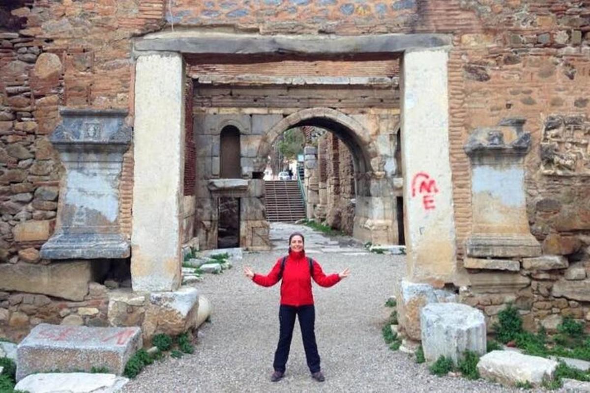 uma mulher em pé em frente a um arco