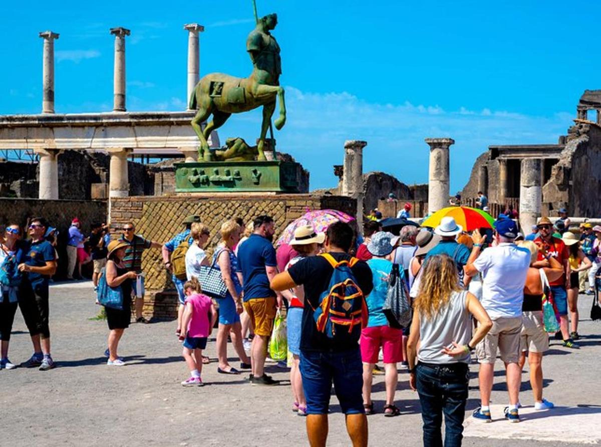 una multitud de persones dempeus davant d'una estàtua