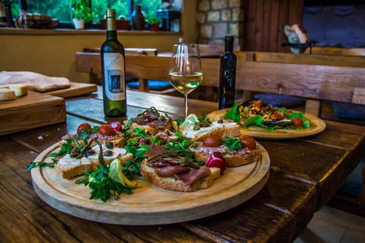 a table with two plates of food and a glass of wine