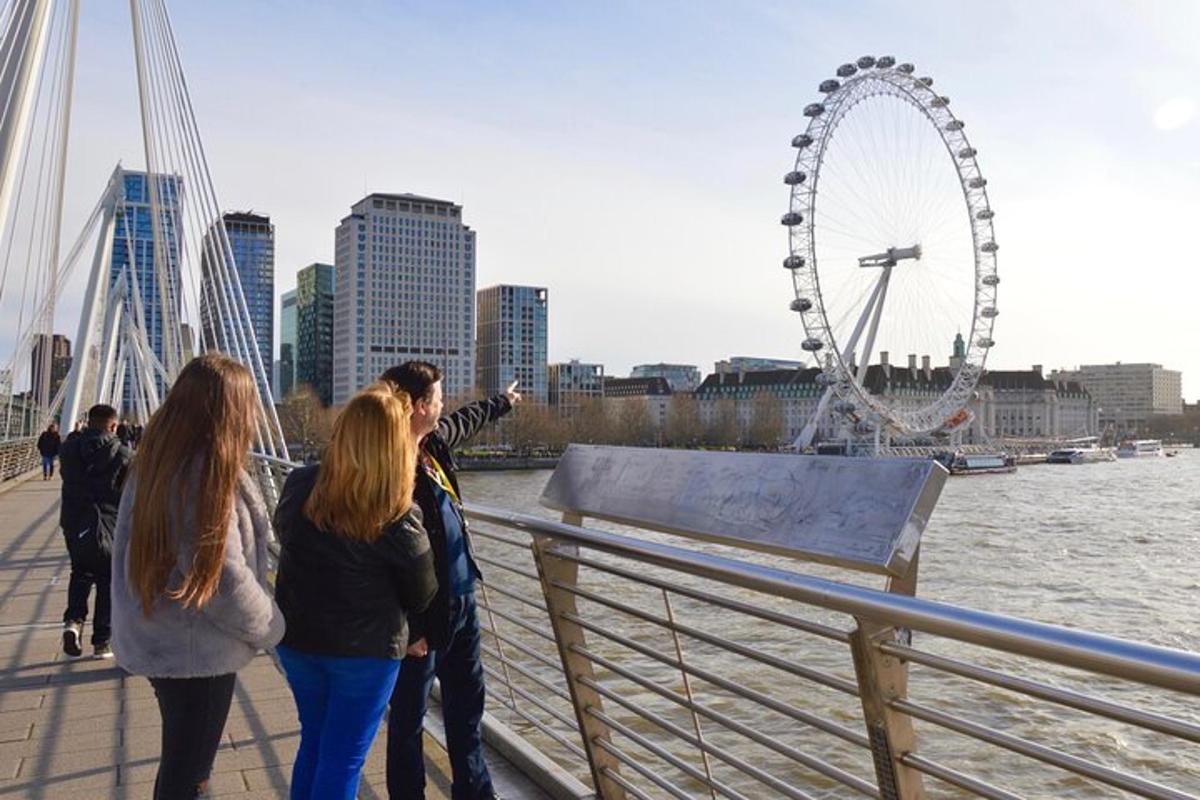 Un grupo de personas de pie en un puente mirando el London Eye.