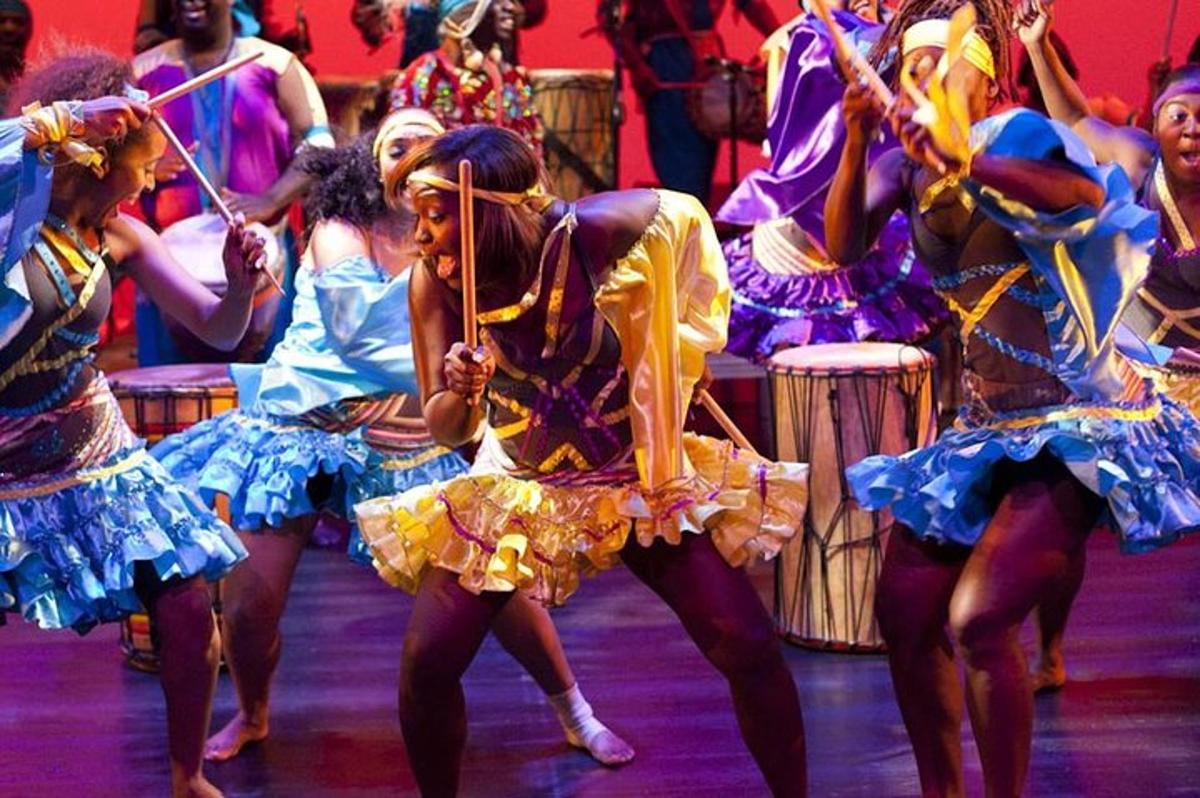 a group of women in dresses dancing on a stage