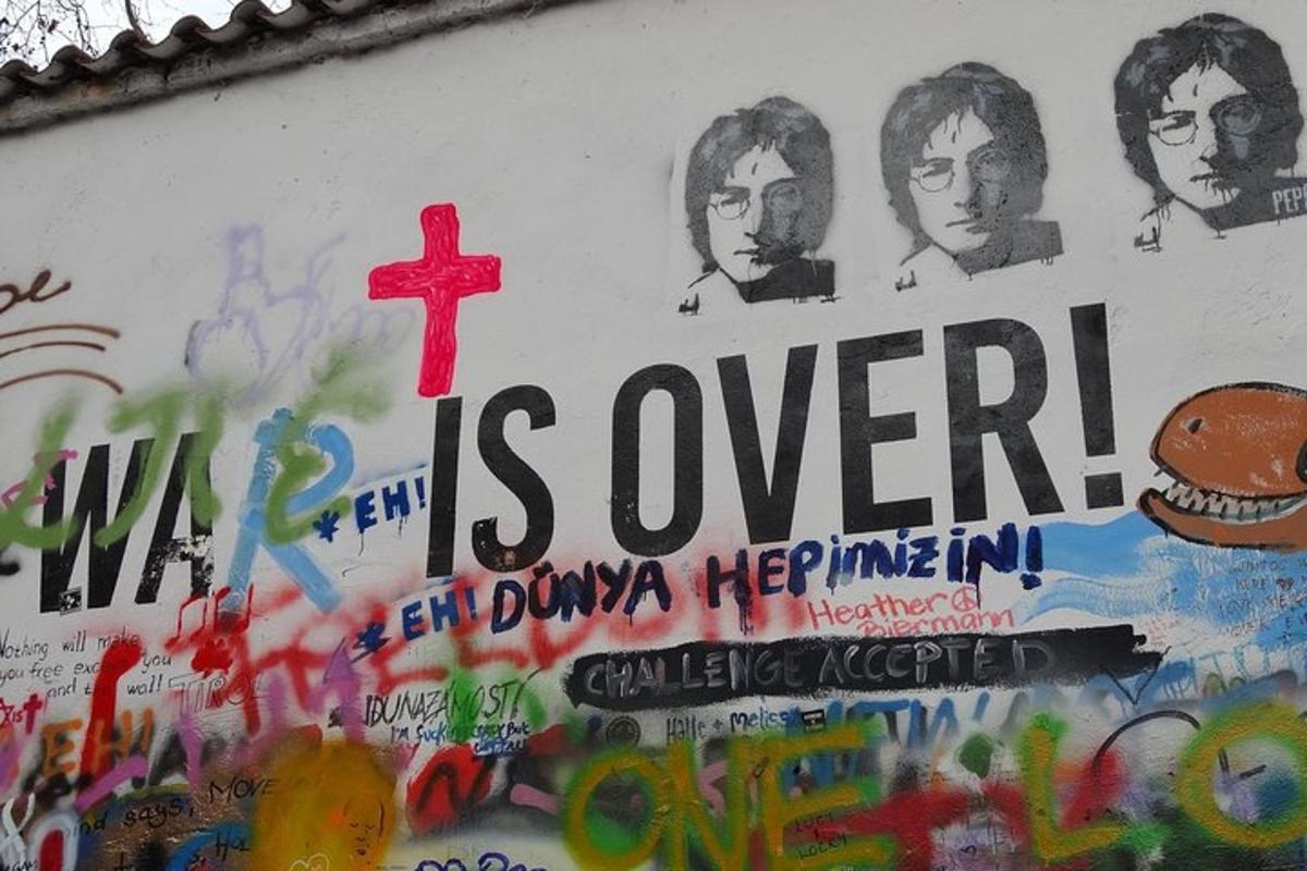 un muro coperto di graffiti con una croce sopra
