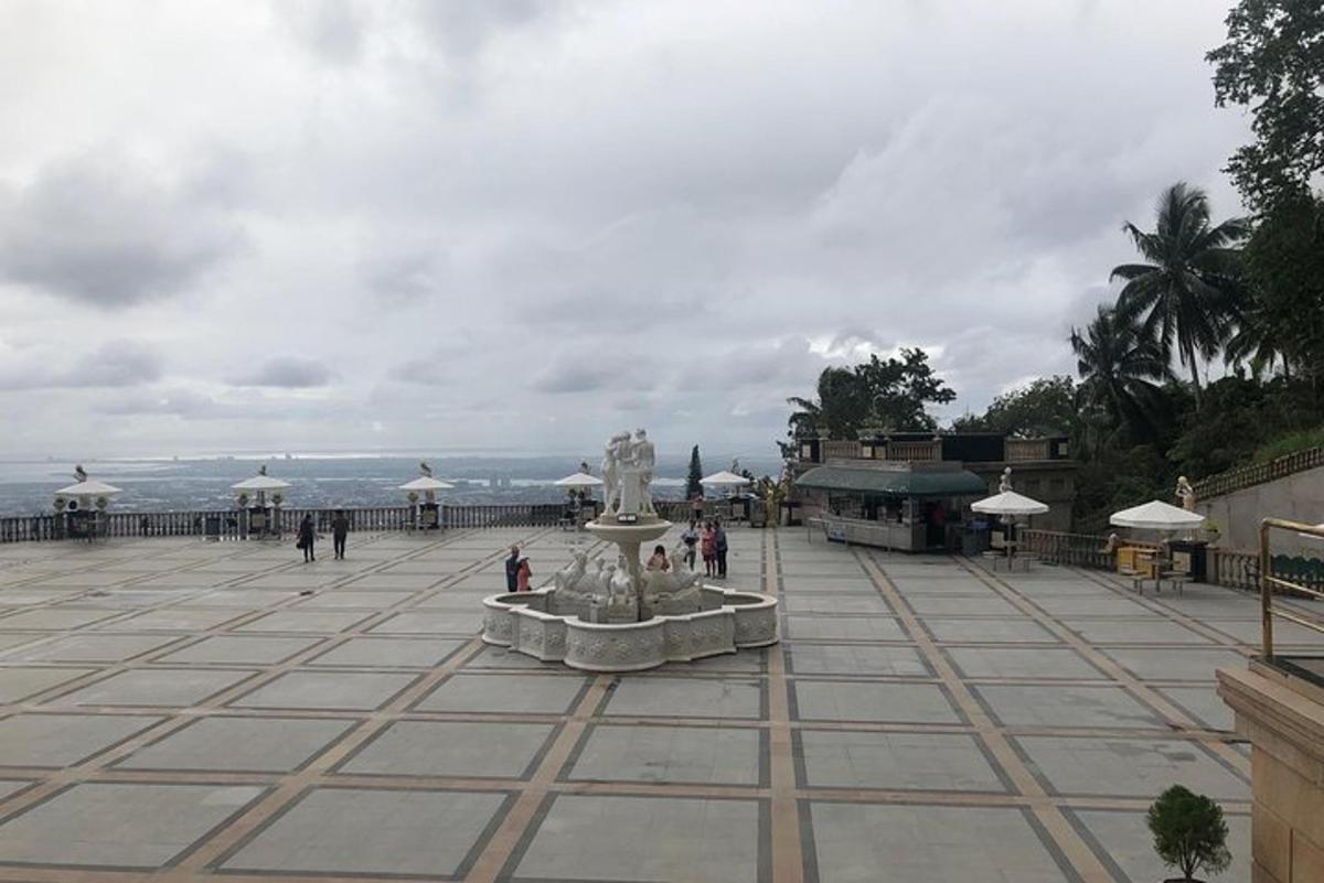 a fountain in the middle of a square with the ocean