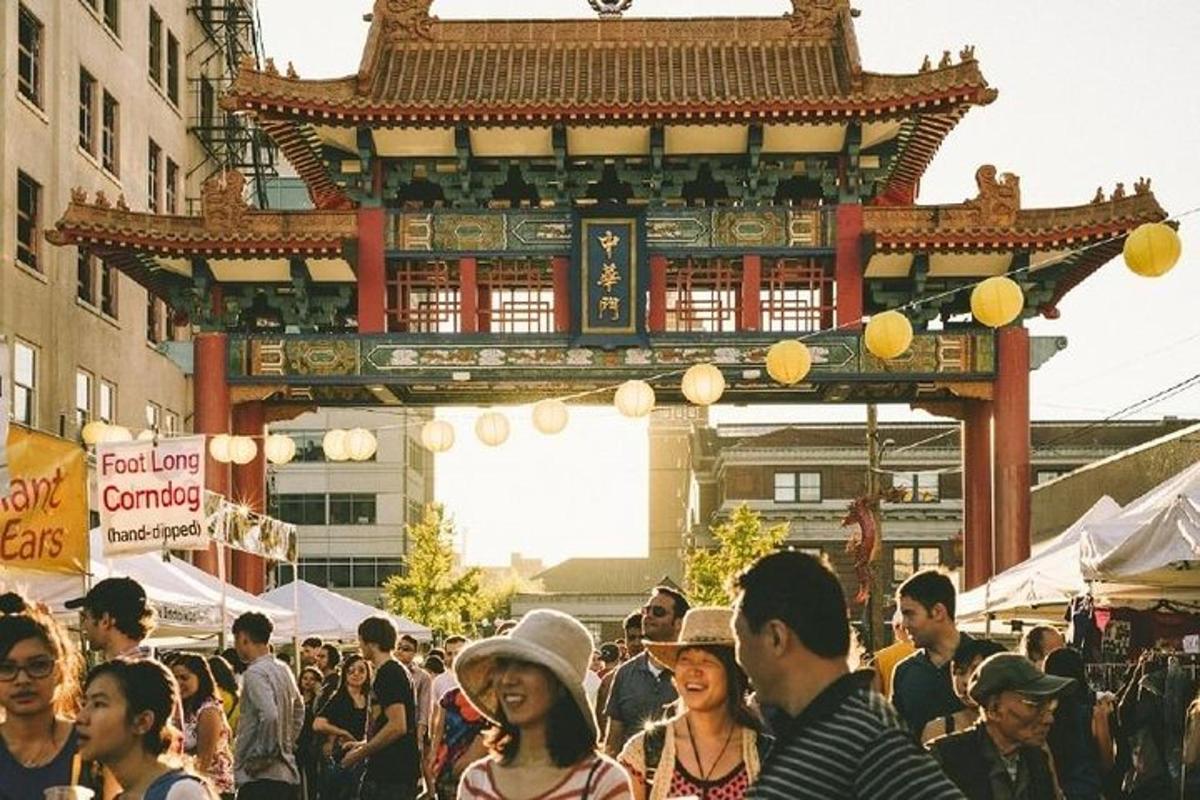 a crowd of people walking around a market with a building