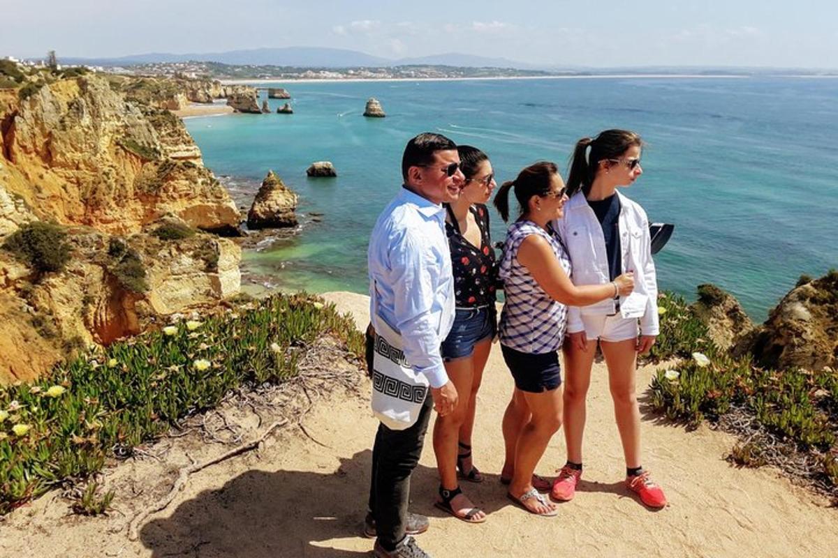 Μια ομάδα ανθρώπων που στέκονται σε έναν απότομο βράχο με θέα τον ωκεανό