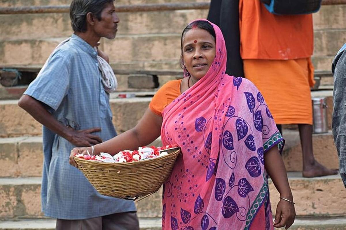 Una mujer con un vestido rosa sosteniendo una canasta de comida.