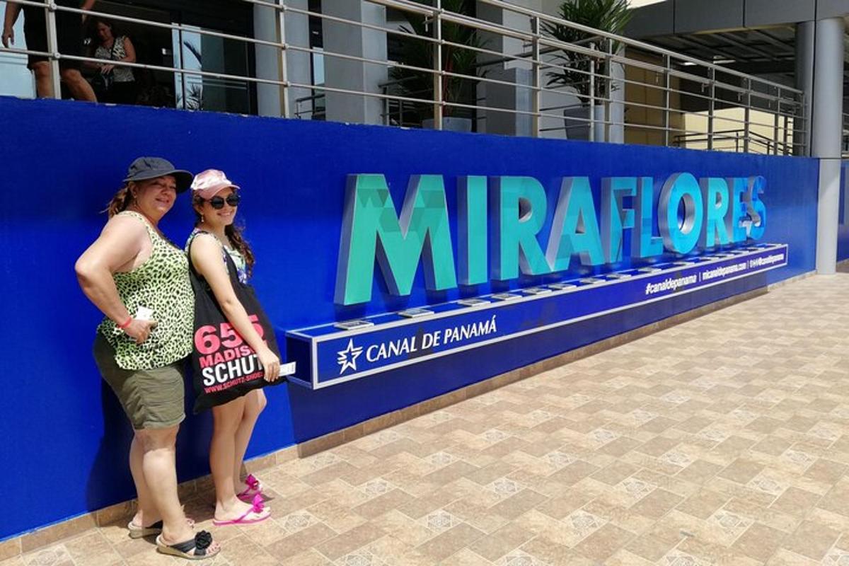 two women are standing in front of a sign