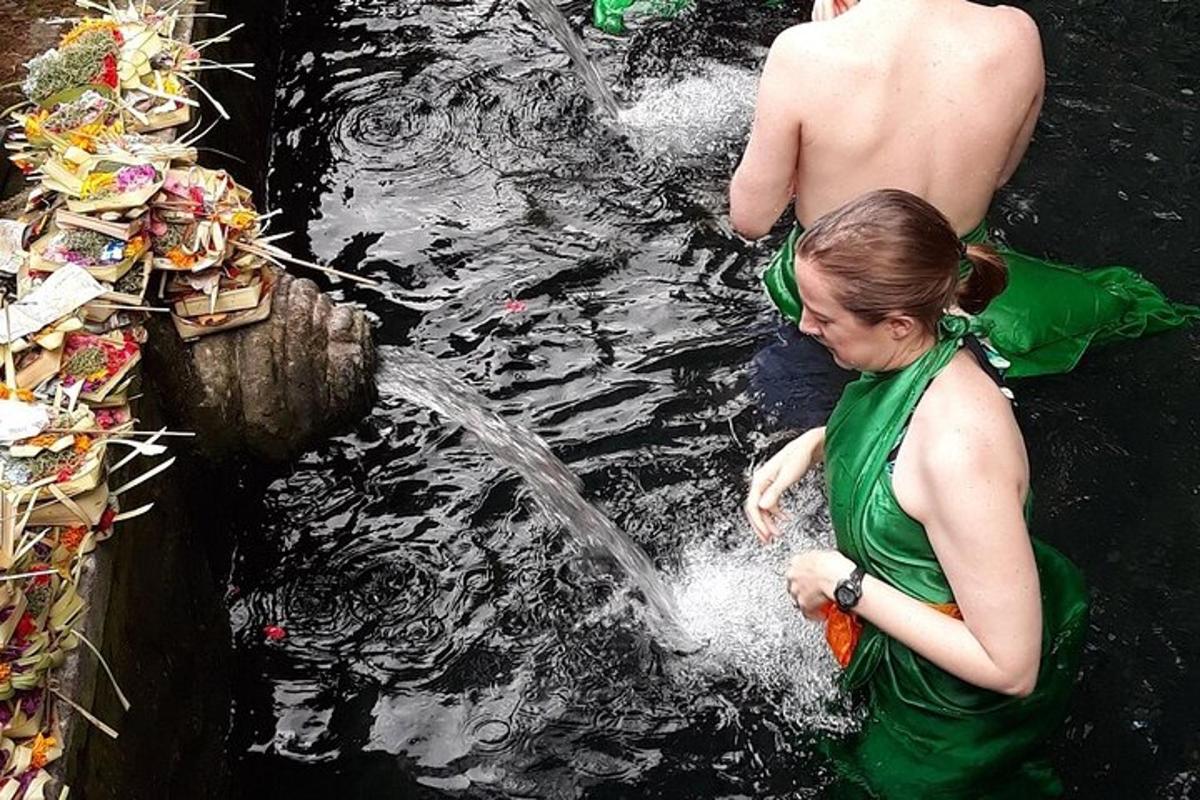 kona stendur í vatninu við hliðina á gosbrunni