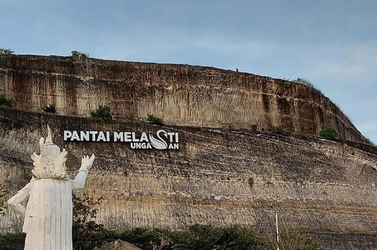 una estàtua davant d'una paret amb un rètol