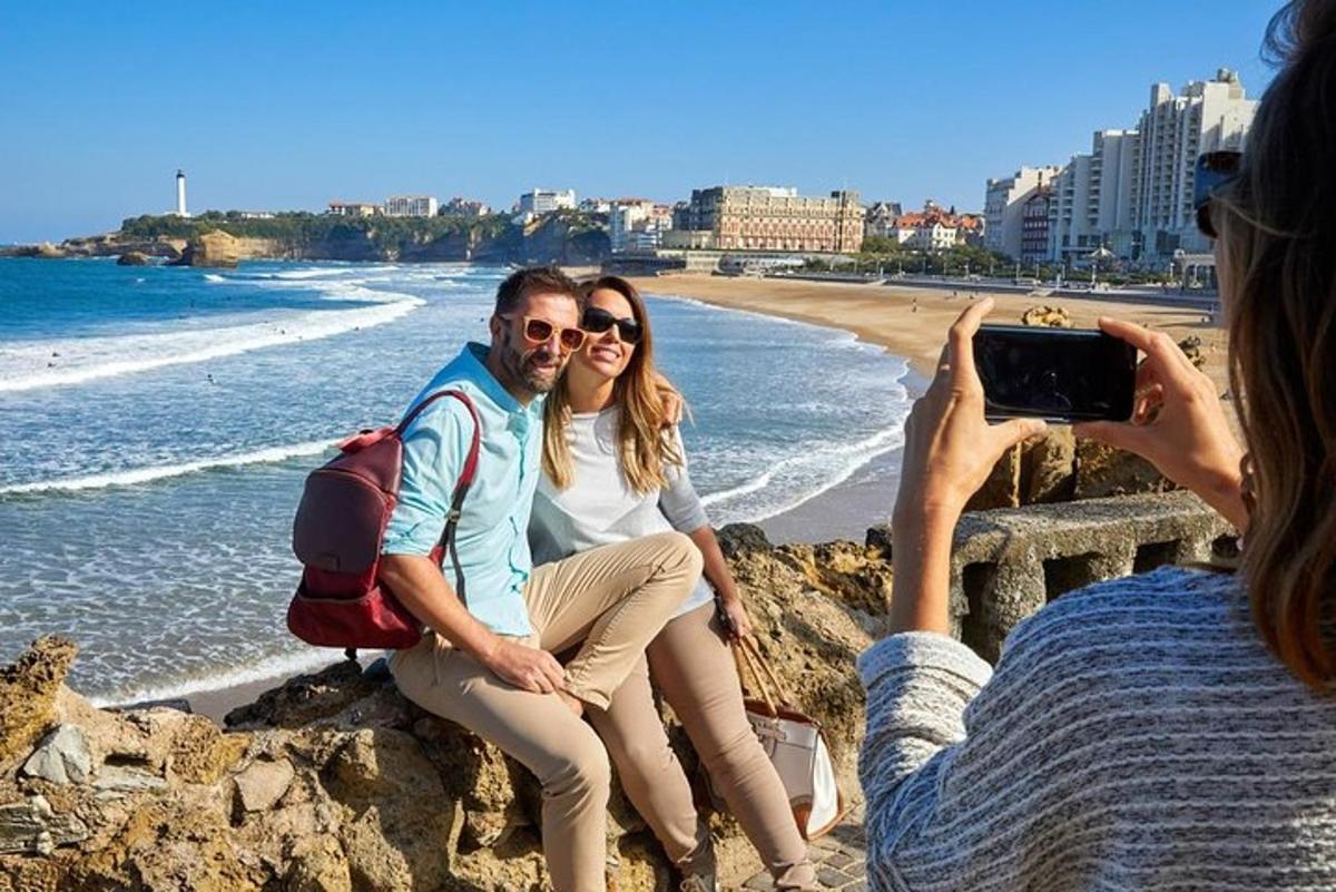 uma mulher tirando uma foto de duas pessoas na praia